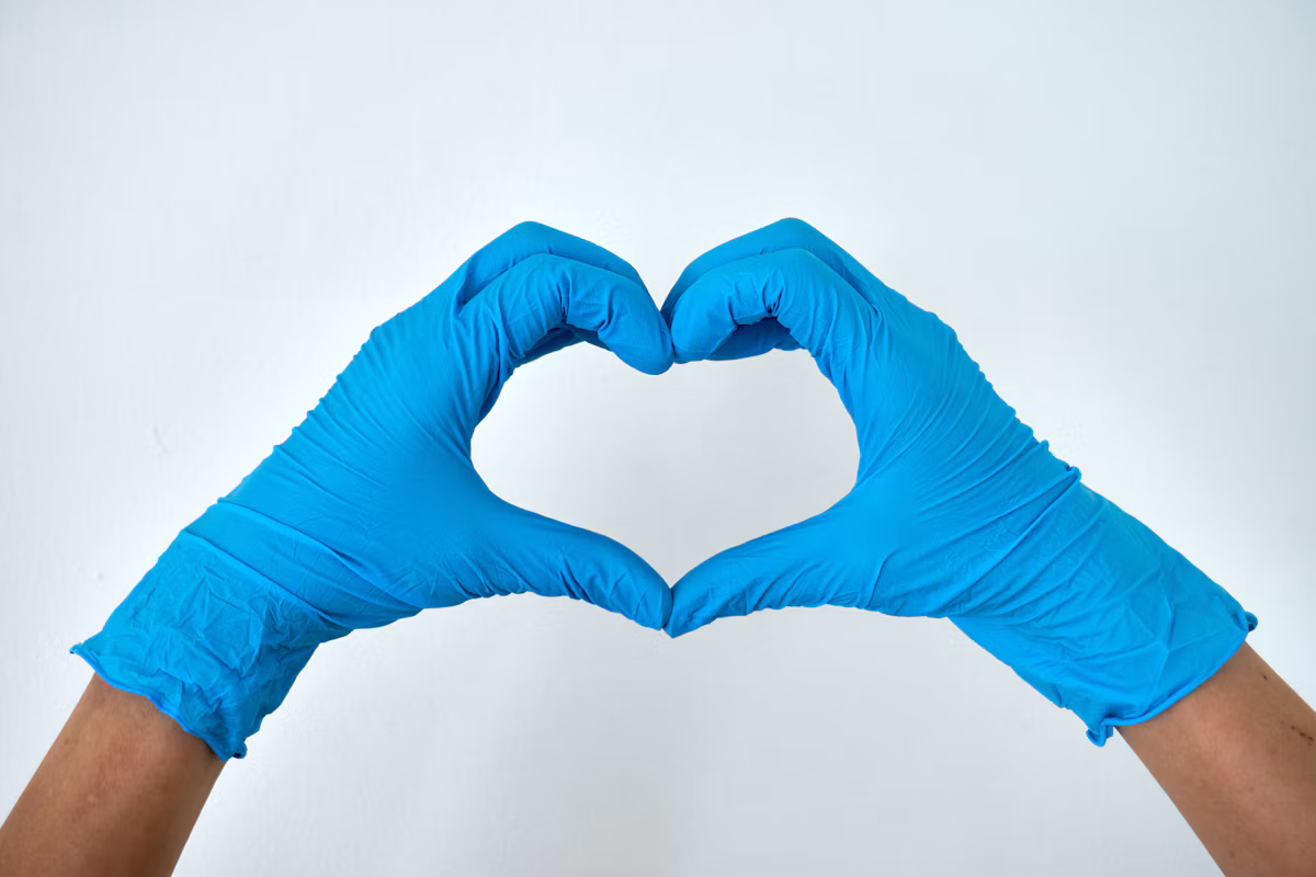 Stock photo of blue cleaning gloves held in a heart shape