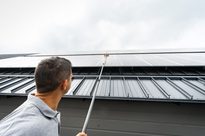 Remarkable team member cleaning roof-mounted solar panels